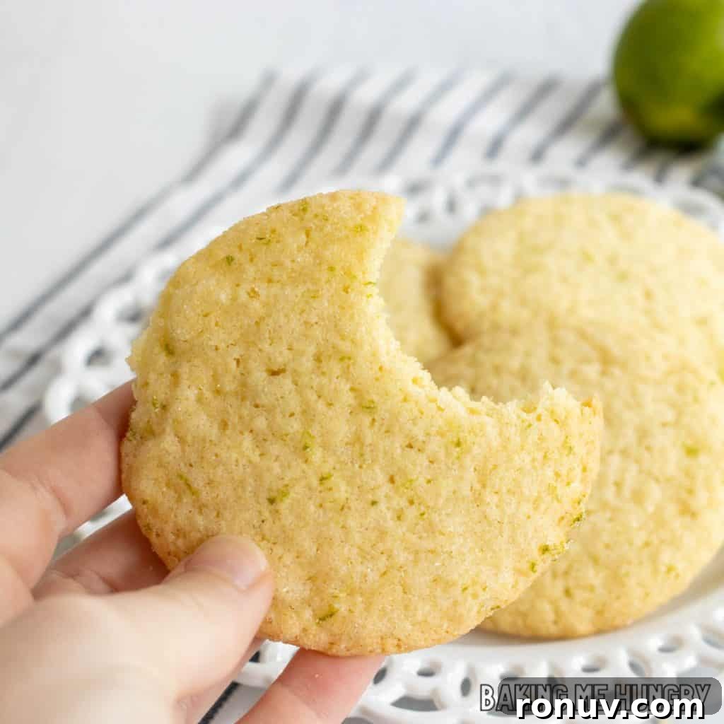Zesty Lime Sugar Cookies with Citrus Glaze 12 hand holding one of the lime sugar cookies missing a bite