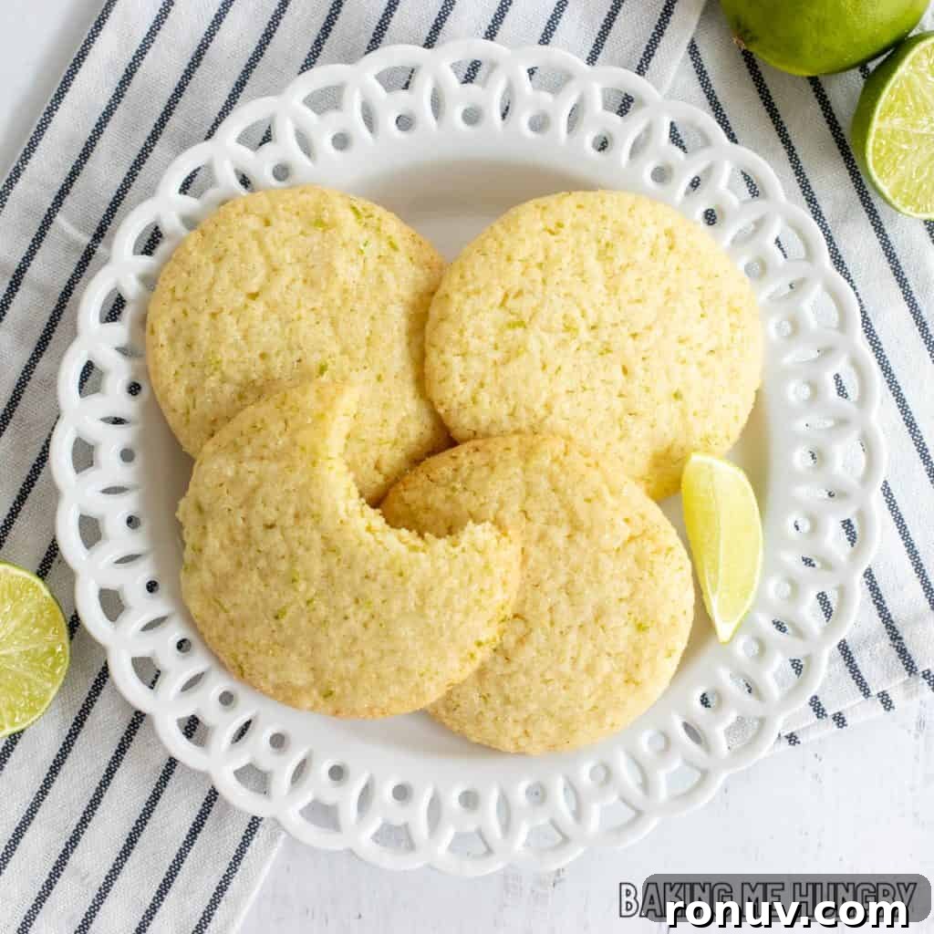 Zesty Lime Sugar Cookies with Citrus Glaze 3 lime sugar cookies with one missing a bite on a plate close up