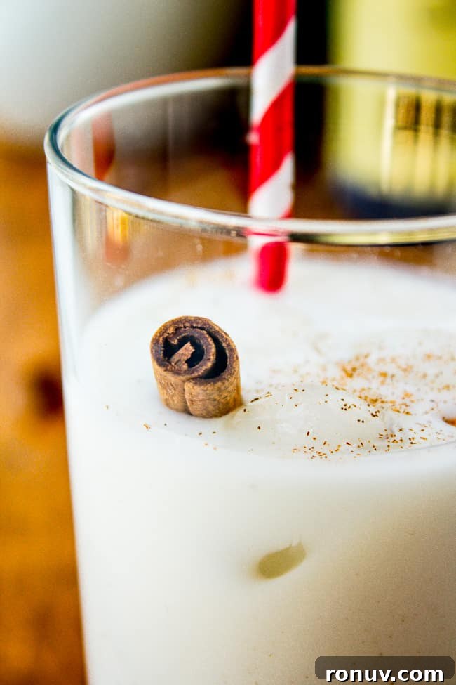 How to Make Authentic Mexican Horchata 2 horchata in a glass with a striped straw and a cinnamon stick.