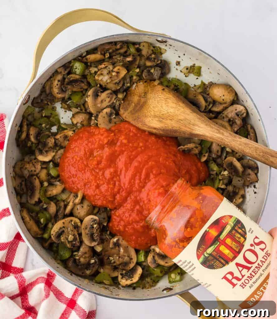 adding pasta sauce to vegetables