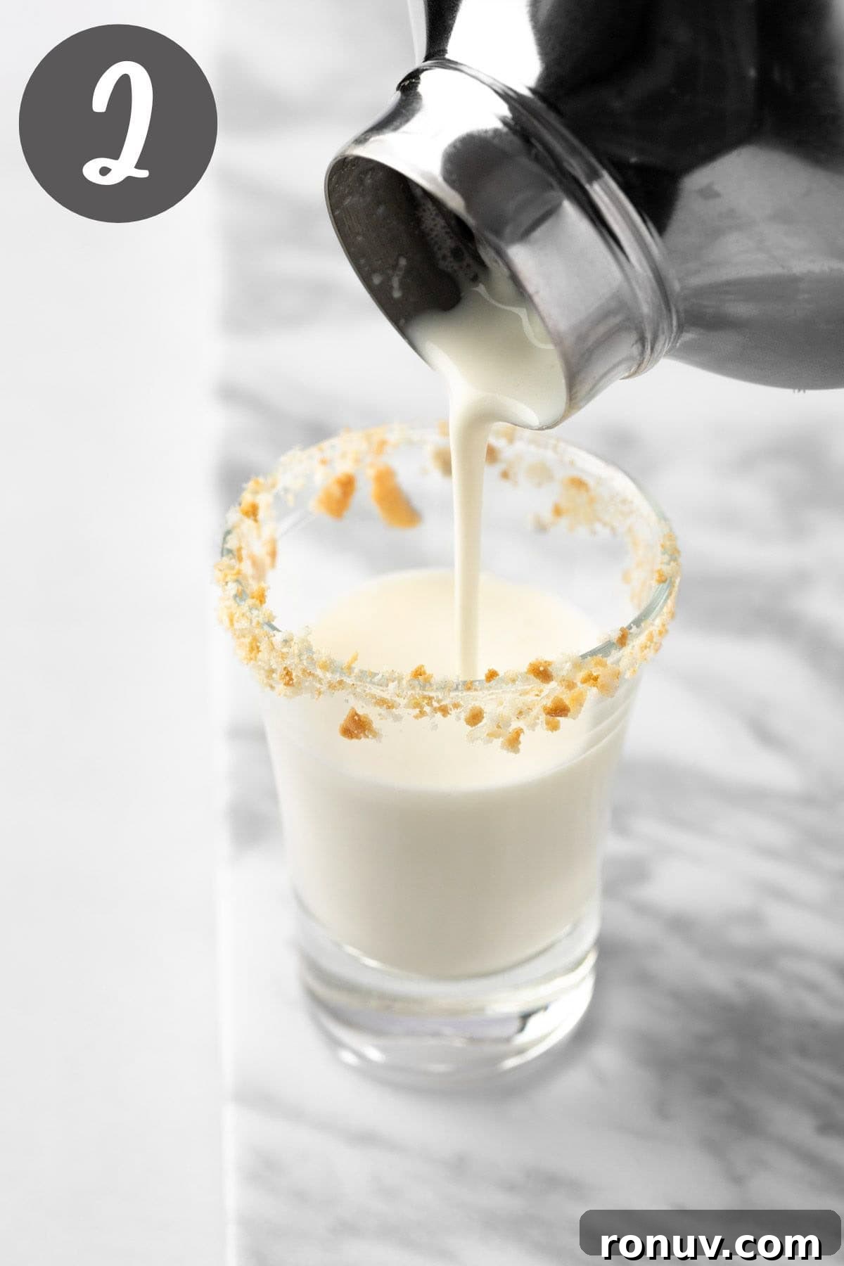 Key Lime Pie Shot Recipe: Creamy Citrus Shooter 5 Pouring the key lime pie shot from the cocktail glass into the shot glass.
