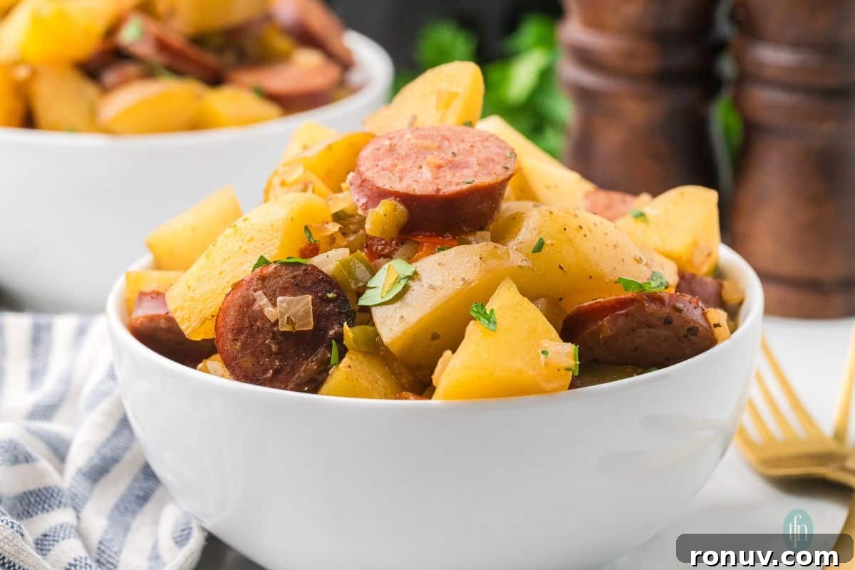 Slow Cooker Sausage and Potatoes 3 a horizontal image of a bowl of sausages and potatoes in slow cooker