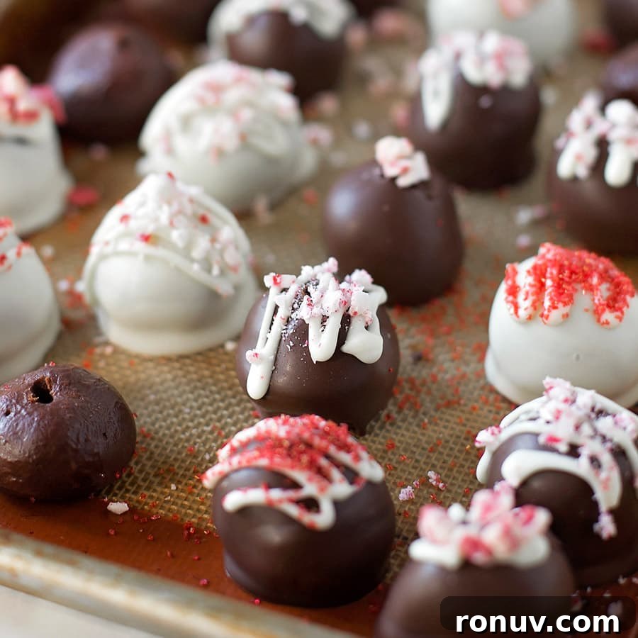 Easy homemade peppermint chocolate truffles are simple and the perfect addition to any holiday party or cookie tray. Peppermint Chocolate Truffles lined up on a cookie sheet