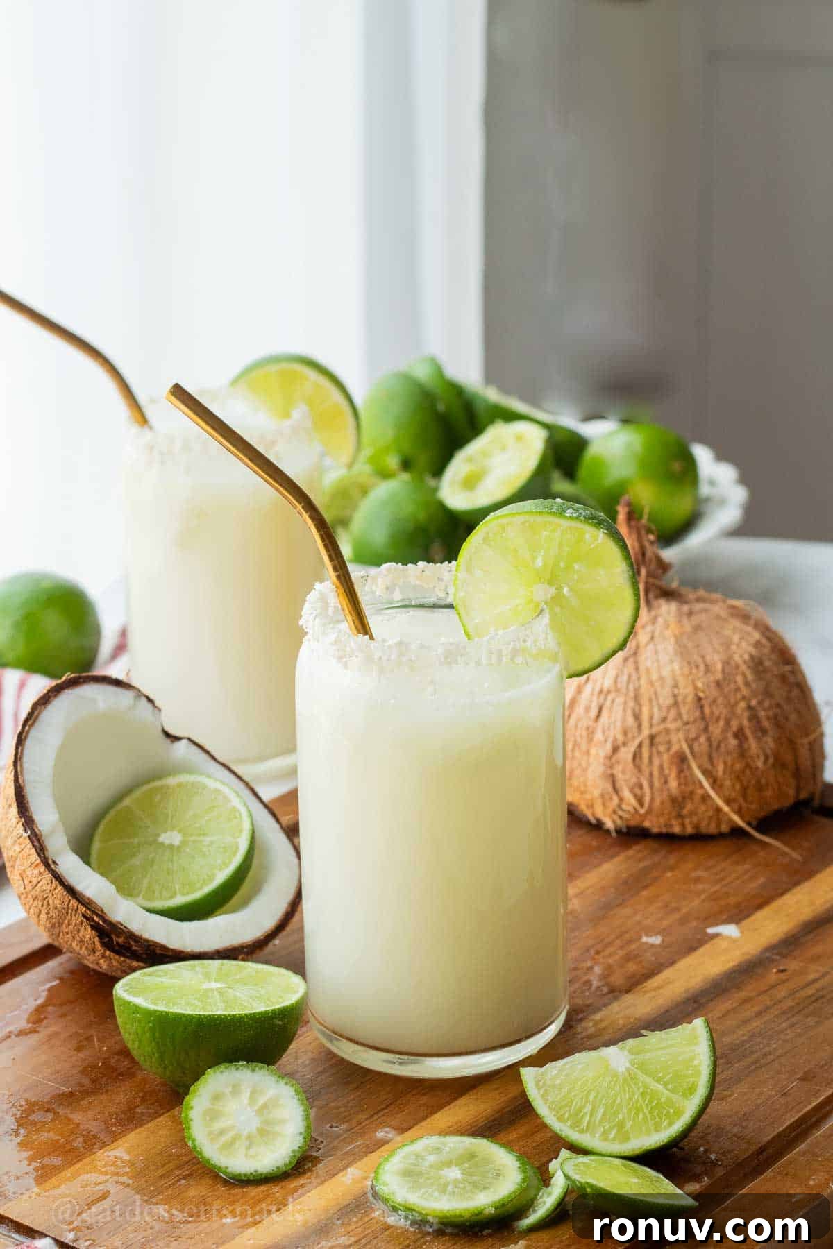 Coconut Lime Cooler: Tropical Drink Recipe 2 Glass of lime in the coconut drink with straw and lime slice and pitcher of limeade.
