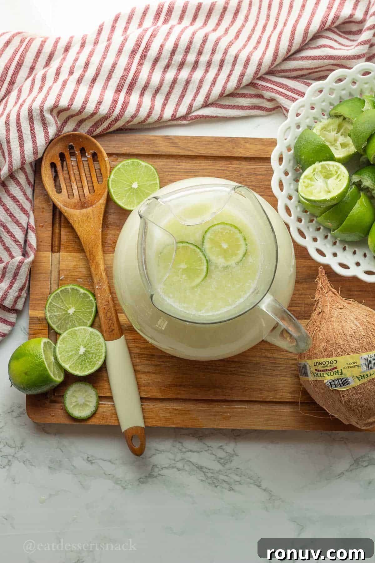 Coconut Lime Cooler: Tropical Drink Recipe 7 Pitcher of lime drink with lime slices.