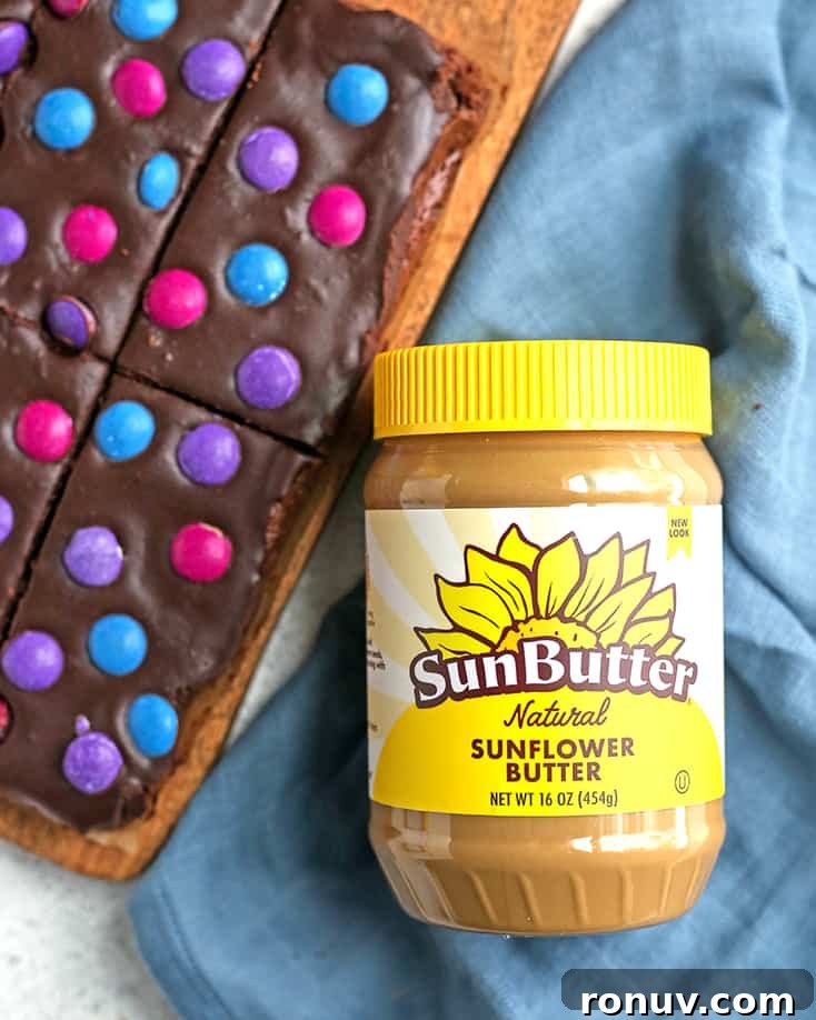 a jar of sunbutter with a plate of cosmic brownies 
