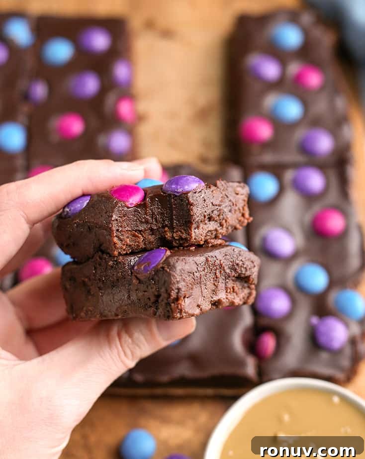 hand holding a stack of two paleo brownies with a bite taken out of the top one 