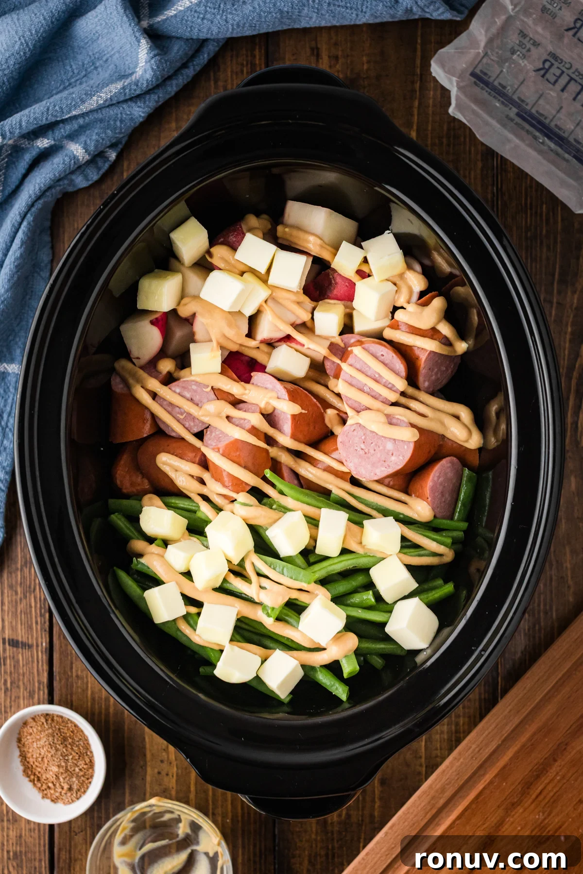 Slow Cooker Kielbasa Dinner Recipe with Potatoes 5 Cubed butter on top of ingredients in a slow cooker.