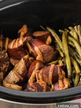 Kielbasa, green beans, and potatoes in a crockpot after cooking.