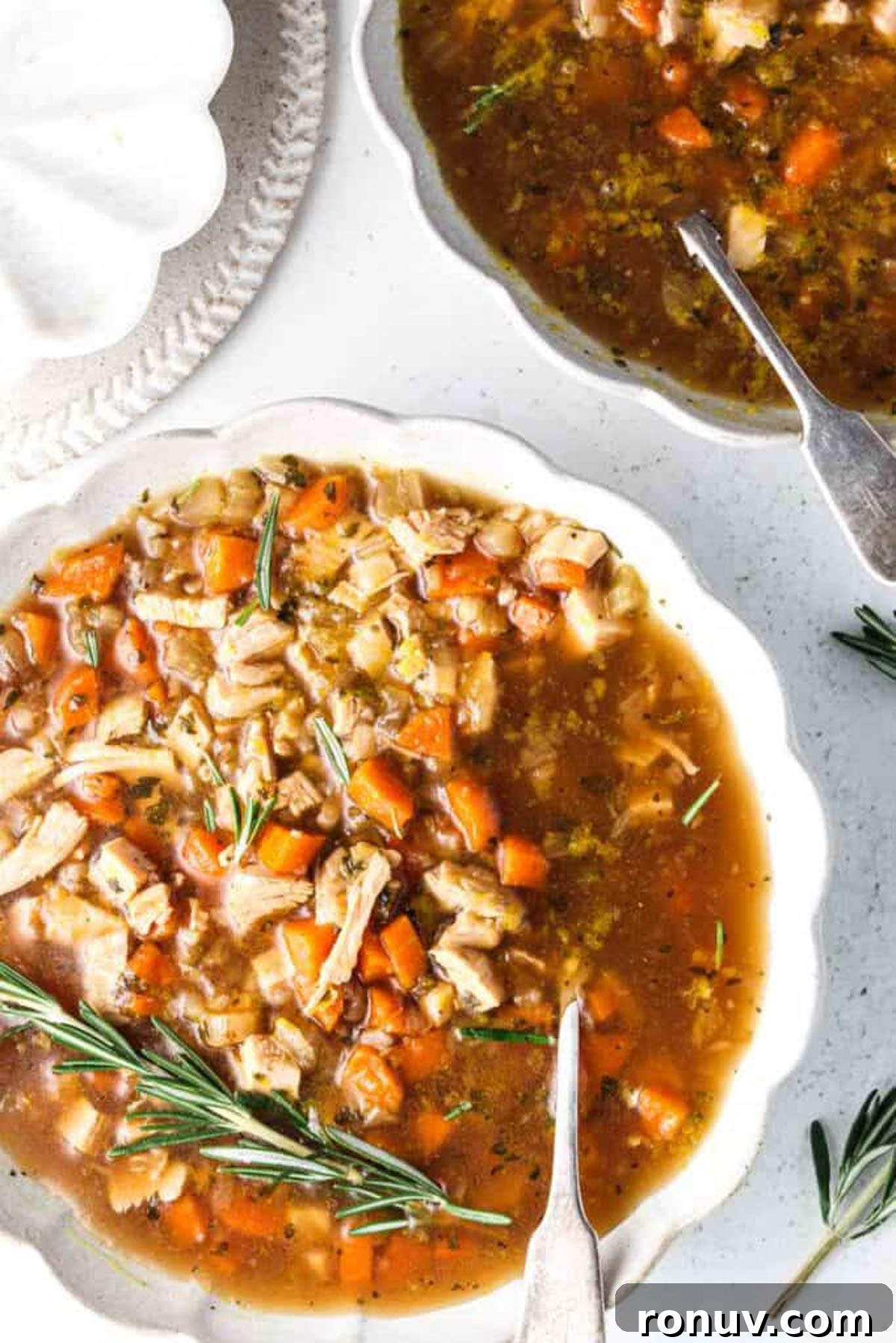 instant pot turkey soup 1 Instant pot turkey soup in a white bowl with fresh rosemary and a spoon.