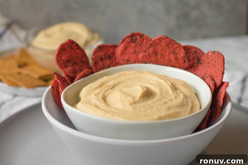 Creamy Homemade Hummus Recipe with Garlic and Lemon 3 homemade hummus in a white bowl with beet crackers around the edge