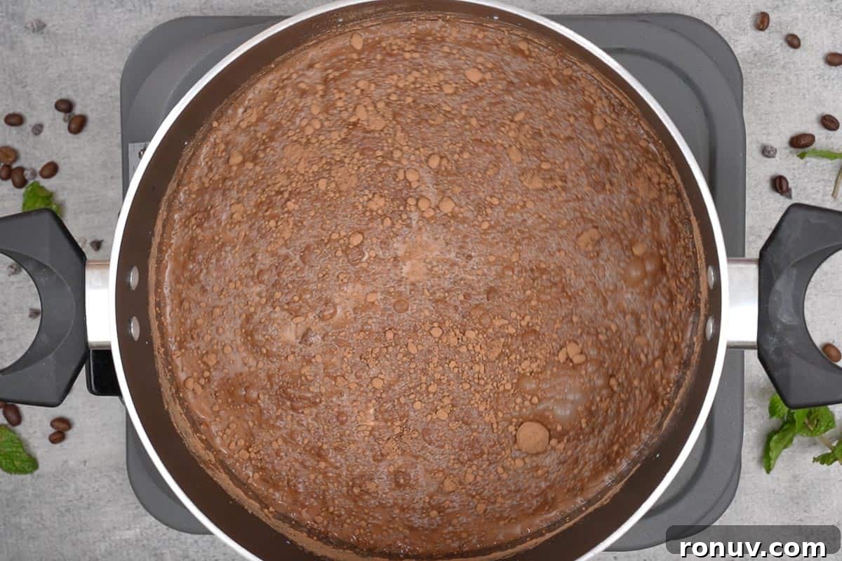 How to Make Espresso Hot Chocolate 4 Milk, cream, water, sugar, and cocoa powder added to a pan.