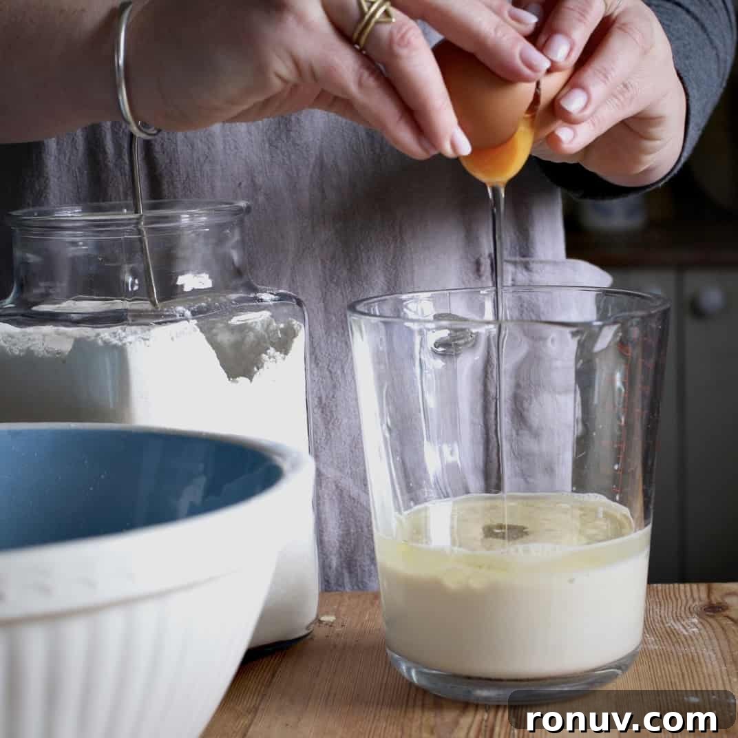 Savory Cheese and Red Onion Muffins: Budget-Friendly Snack 7 Woman cracking an egg into milk and oil