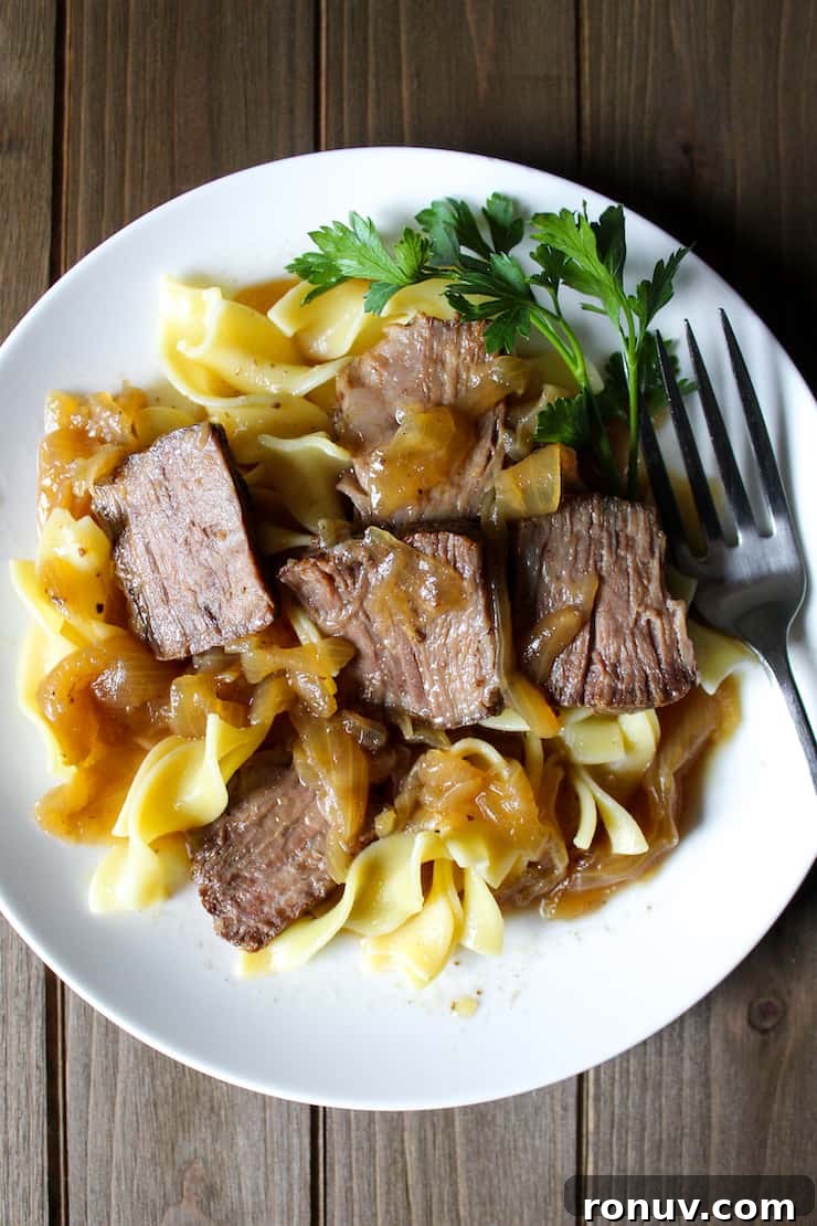 Beer-Braised Beef with Caramelized Onions Recipe 6 Beer braised beef and onions over egg noodles with fork