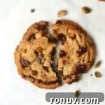 Single serve pistachio chocolate chunk cookie broken in half.