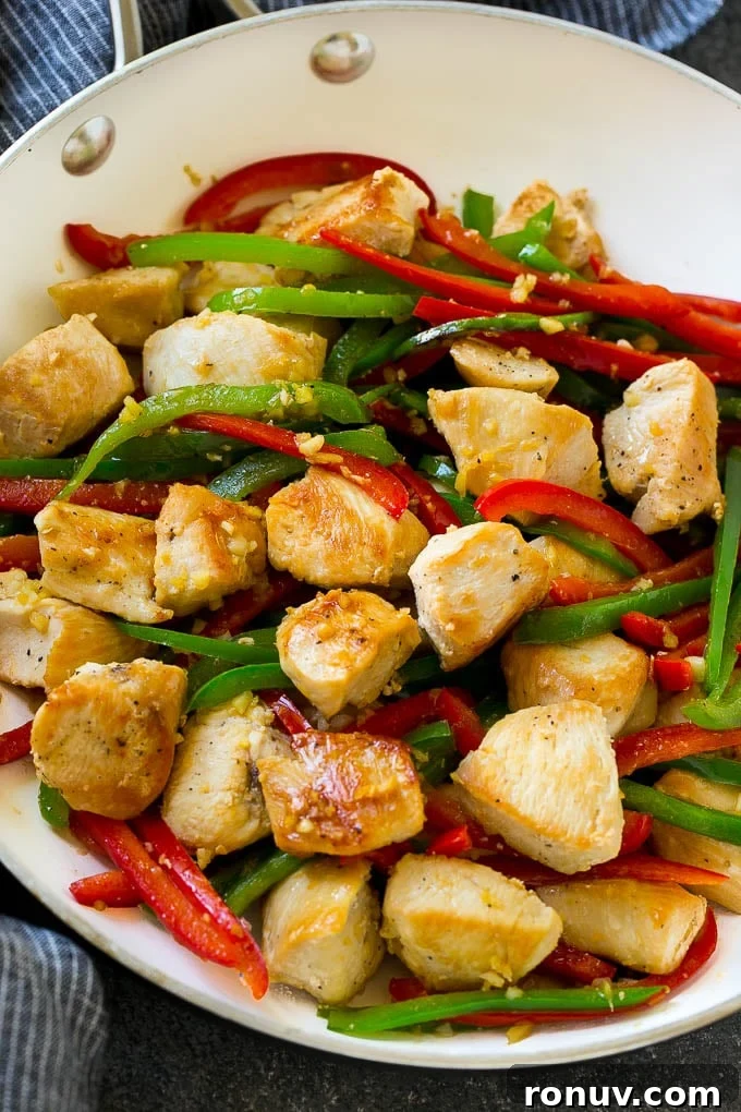 Chicken and peppers in skillet Chicken, bell peppers, garlic and ginger in a skillet.