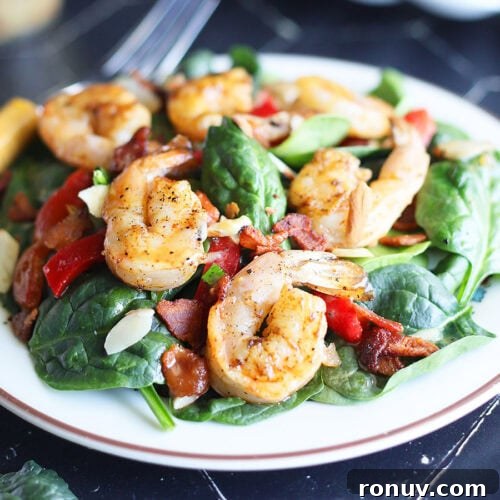 Plated grilled shrimp salad with a fork on the side.