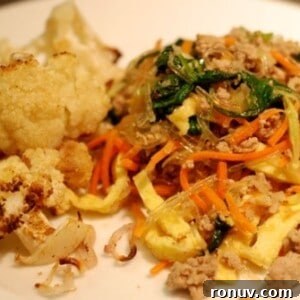 A plate with roasted cauliflower and paleo stir-fried kelp noodles with pork, eggs, and broccoli slaw.