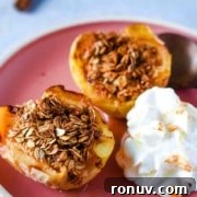 Air fryer baked apples on a pink plate with whipped cream.
