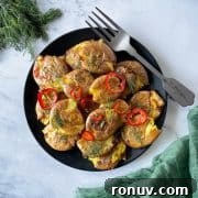 Smashed air fryer potatoes dressed in lemon, rosemary, and chili vinaigrette on a black plate.