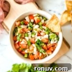 An overhead shot of garden fresh salsa in a white bowl.