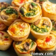 A plate with a stack of mini quiches filled with cheese, spinach, and chopped peppers.