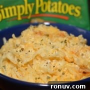 A blue bowl filled with cooked hash browns topped with seasoning.