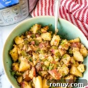 A bowl of cooked potato salad with herbs and an Instant Pot in the background.
