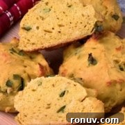 Close-up of bread pieces with herbs on a wooden surface.