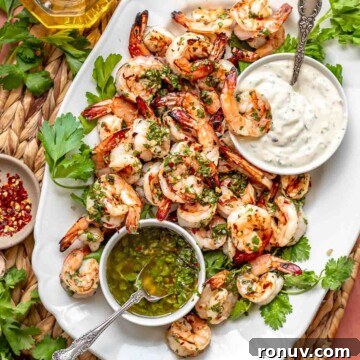 Chimichurri shrimp on a platter with dipping sauces.