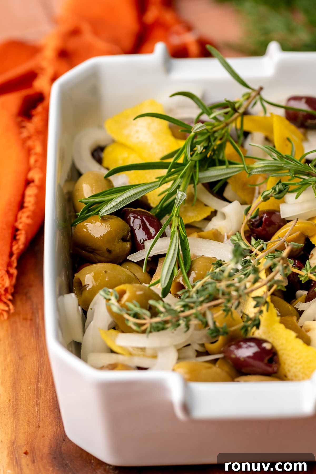 Herb Roasted Olives with Burrata Recipe 6 Olives, onions, and herbs in a baking dish.