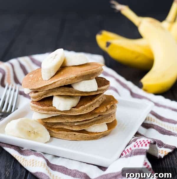 Whole Wheat Banana Pancakes Recipe 3 Banana pancakes layered with sliced bananas.
