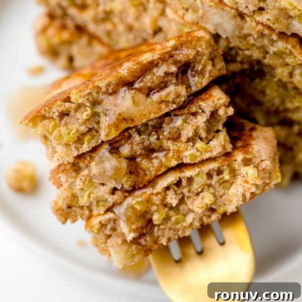 Apple quinoa pancakes on a fork with syrup.