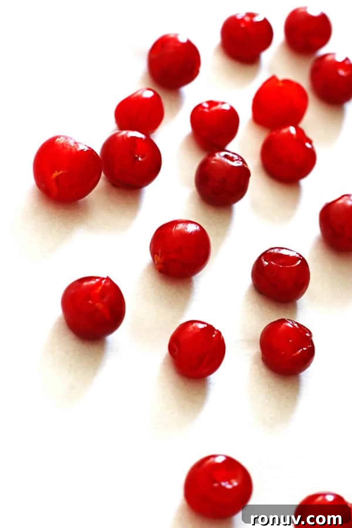 Pitted tart cherries on baking sheet covered with parchment paper