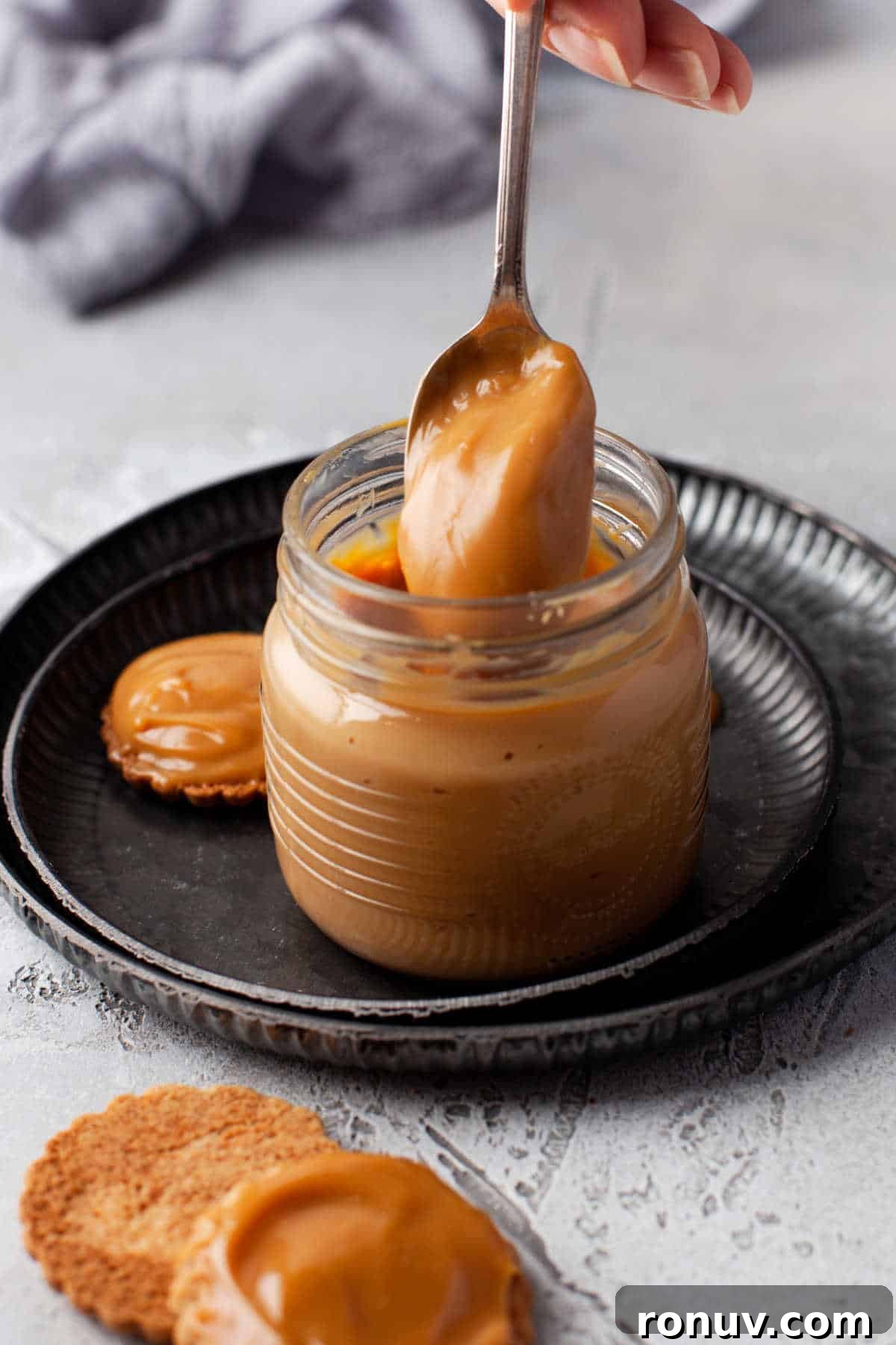 Instant Pot Dulce de Leche Recipe: Creamy Caramel 2 A spoon coming out of a jar of dulce de leche.