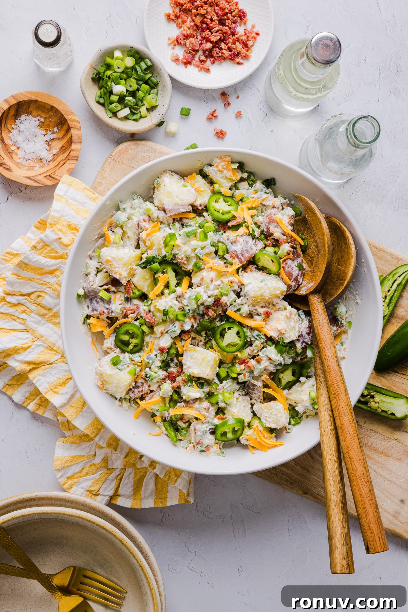 Creamy Jalapeño Popper Potato Salad with Bacon and Cheddar 7 Jalapeño popper potato salad mixed in a bowl with two serving spoons.