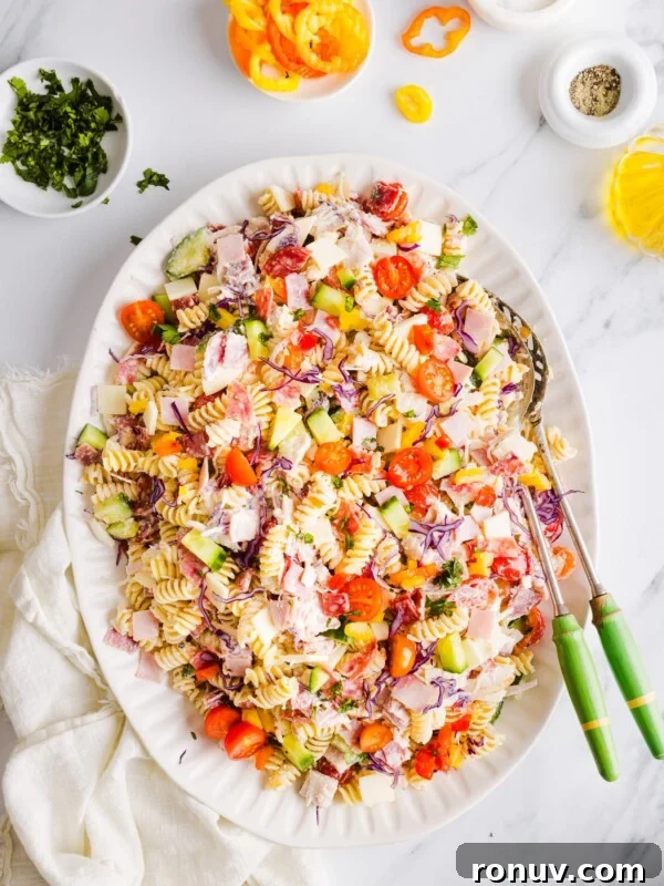 Creamy Jalapeño Popper Potato Salad with Bacon and Cheddar 9 Grinder pasta salad on a large white platter with two serving spoons.