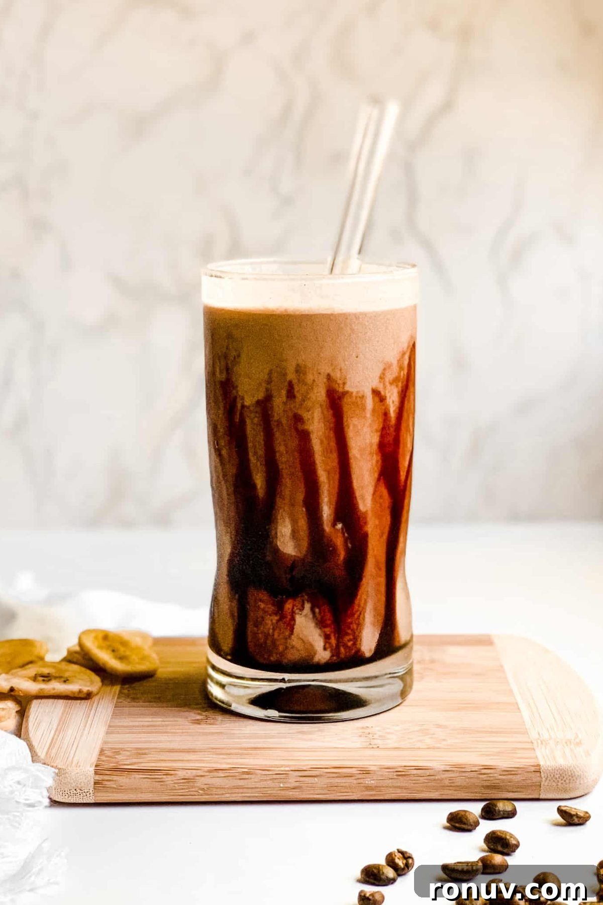 Iced Coffee Protein Smoothie with Date Syrup Creamy Banana Coffee Smoothie in a Tall Glass with Coffee Beans and Sliced Bananas for Food Photography