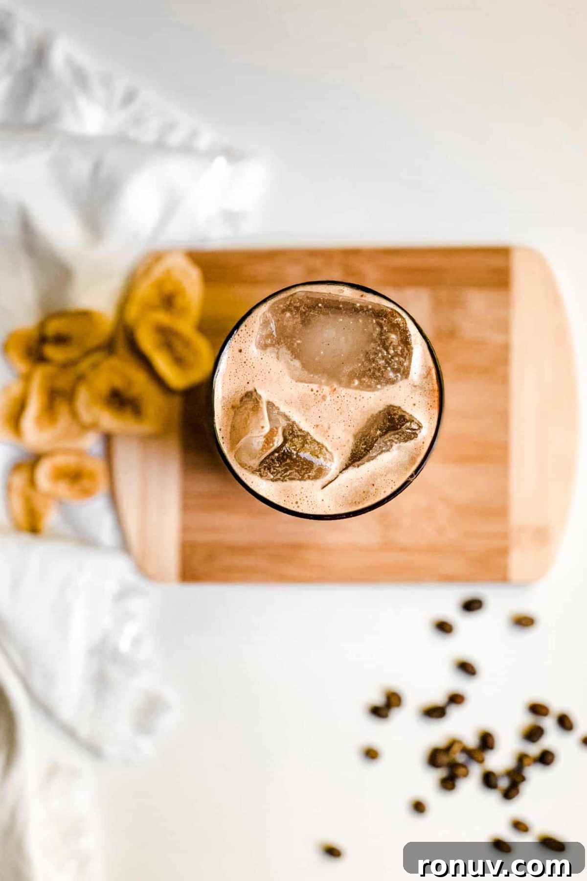 Iced Coffee Protein Smoothie Creamy Banana Coffee Smoothie in a Tall Glass with Coffee Beans and Sliced Bananas for Food Photography