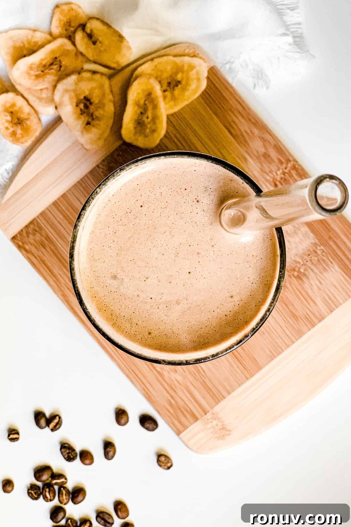 Healthy Iced Coffee Protein Smoothie Creamy Banana Coffee Smoothie in a Tall Glass with Coffee Beans and Sliced Bananas for Food Photography