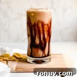 Creamy Banana Coffee Smoothie in a Tall Glass with Coffee Beans and Sliced Bananas for Food Photography