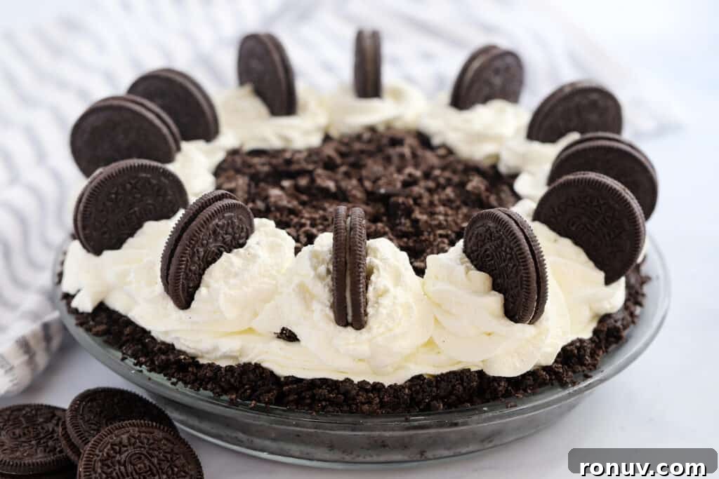 Classic Chocolate Cream Pie Recipe 3 A full Oreo choco Pie in a glass pie dish topped with whipped cream and decorated with Oreo cookies.