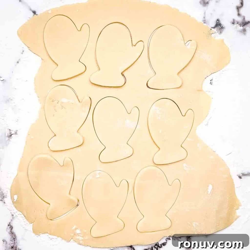 Air Fryer Sugar Cookies Recipe: Soft, Quick Homemade Treat 6 The cookie dough rolled out with cut out shapes of a mitten in the dough.