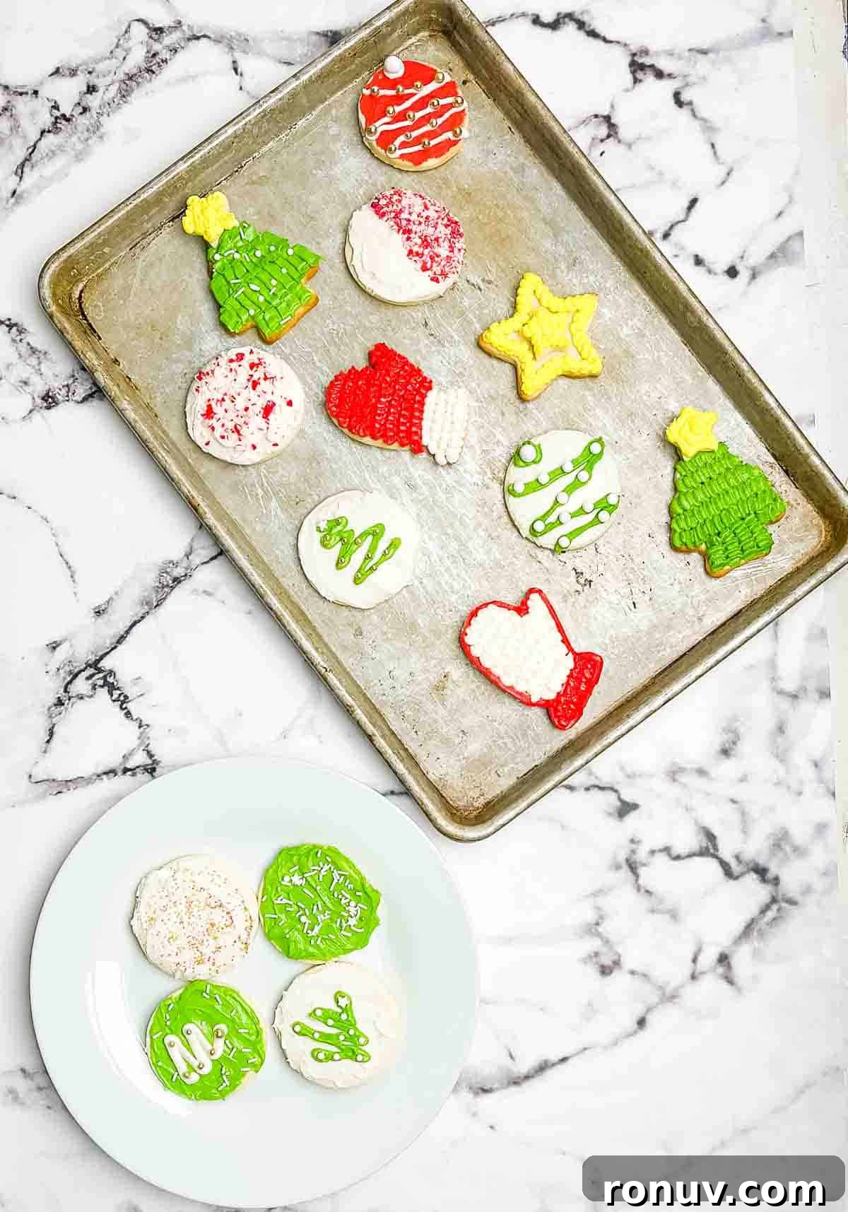 Air Fryer Sugar Cookies Recipe: Soft, Quick Homemade Treat 10 Decorated sugar cookies on a white plate, and some on a large rimmed baking sheet.