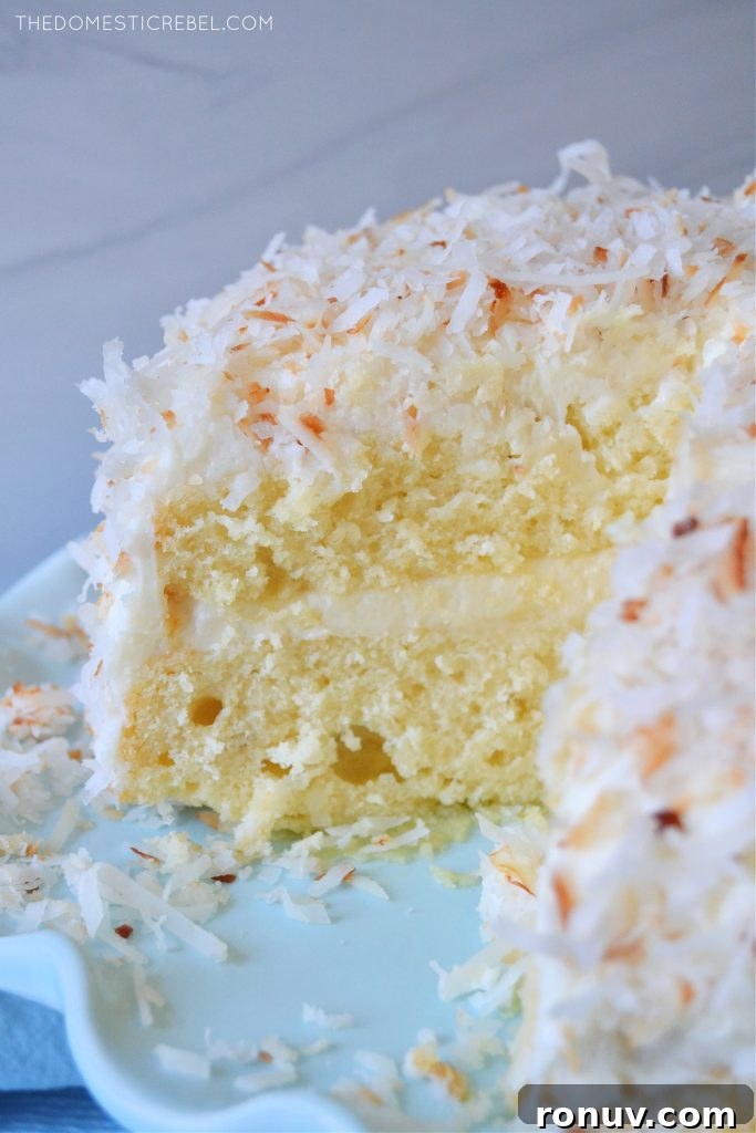 Moist Coconut Layer Cake with Coconut Buttercream 4 coconut layer cake on a blue pedestal