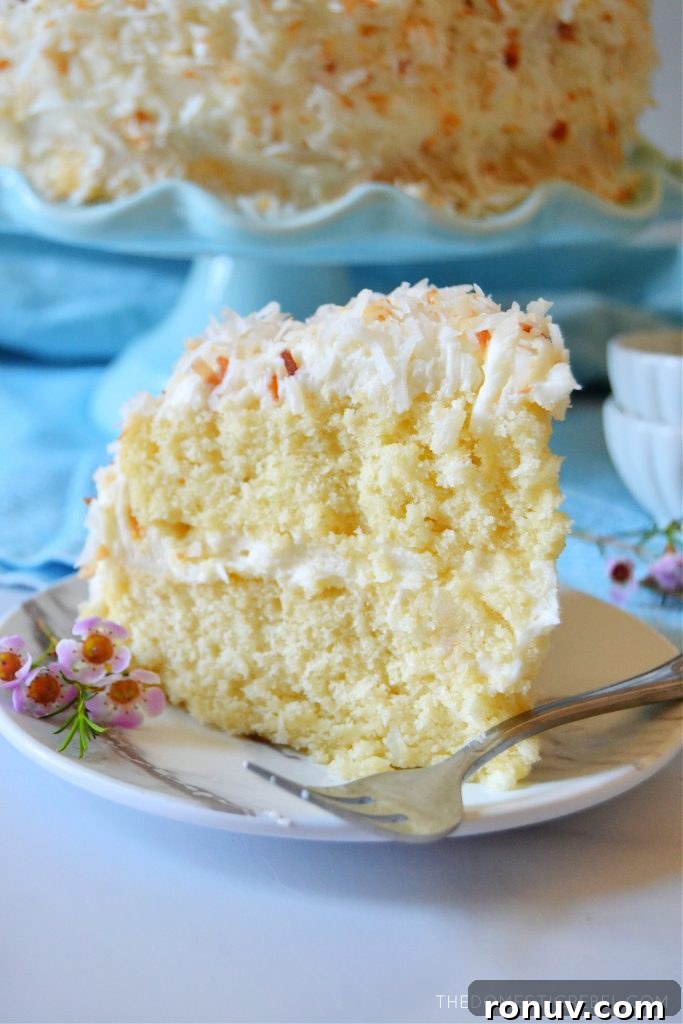 Moist Coconut Layer Cake with Coconut Buttercream 7 coconut layer cake with a fork on a plate
