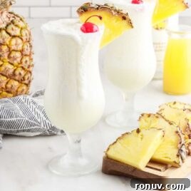 Pina Colada in a glass topped with a cherry and a slice of pineapple