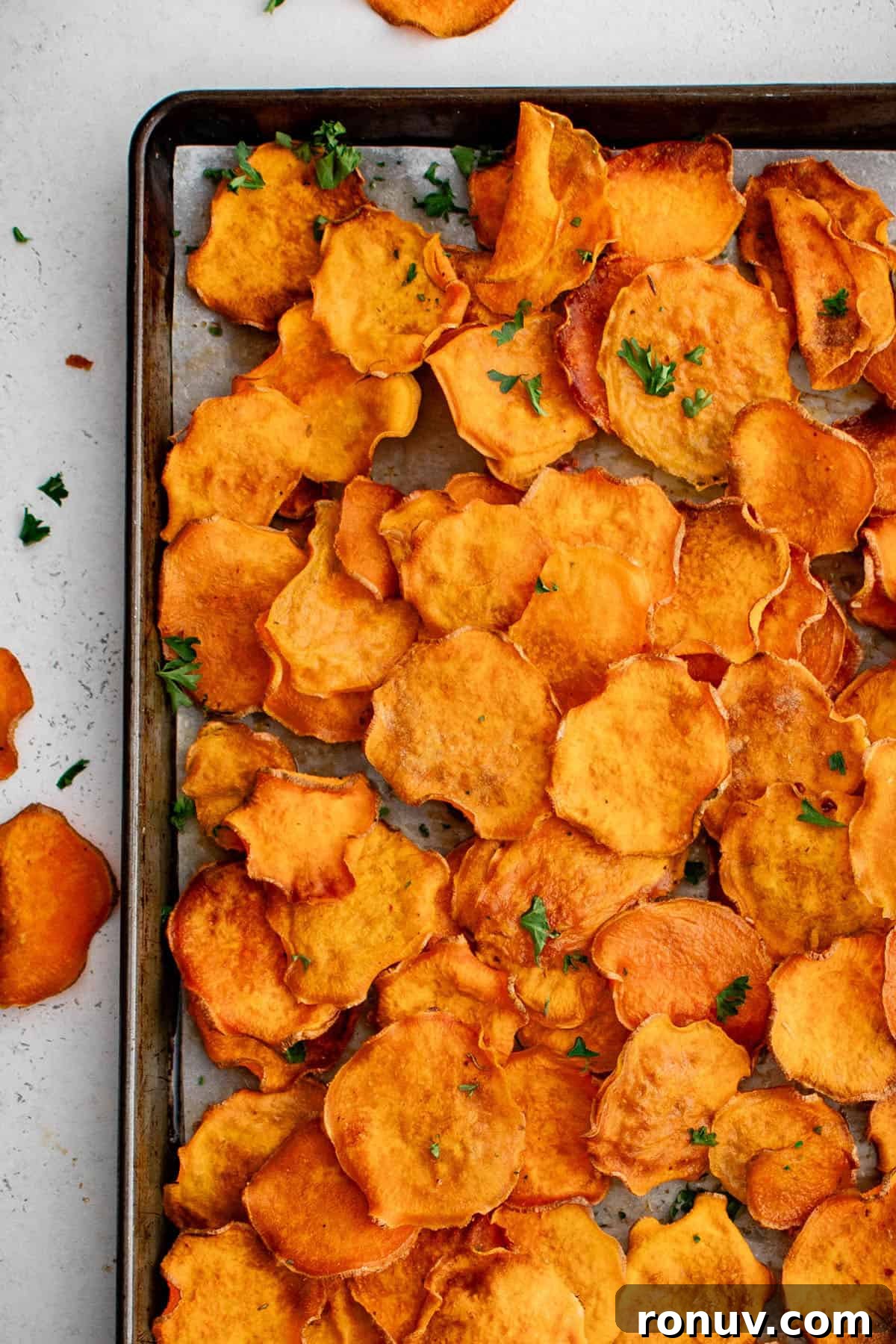 How to Make Crispy Sweet Potato Chips at Home 2 sweet potato chips on a sheet pan