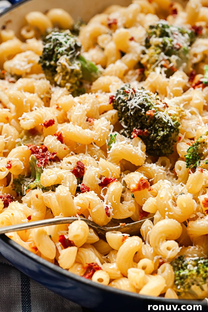 Creamy Broccoli Pasta with Sun-Dried Tomatoes and Parmesan 2 pasta with broccoli and sun-dried tomatoes in a pan