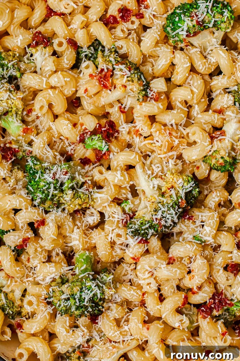 Creamy Broccoli Pasta with Sun-Dried Tomatoes and Parmesan 4 top down view of pasta dish with broccoli and sun-dried tomatoes sprinkled with Parmesan cheese